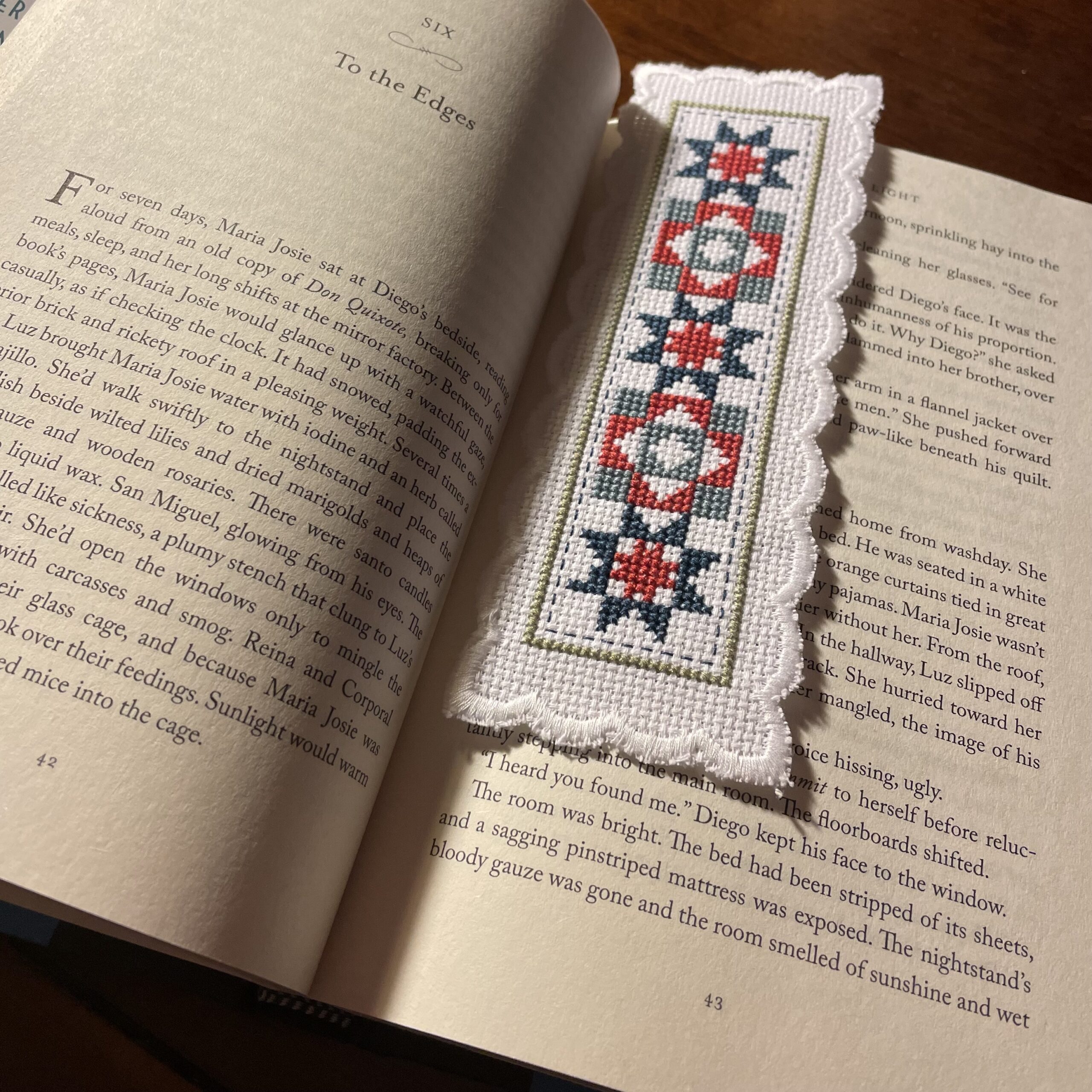 cross-stitched bookmark holding a place in a book