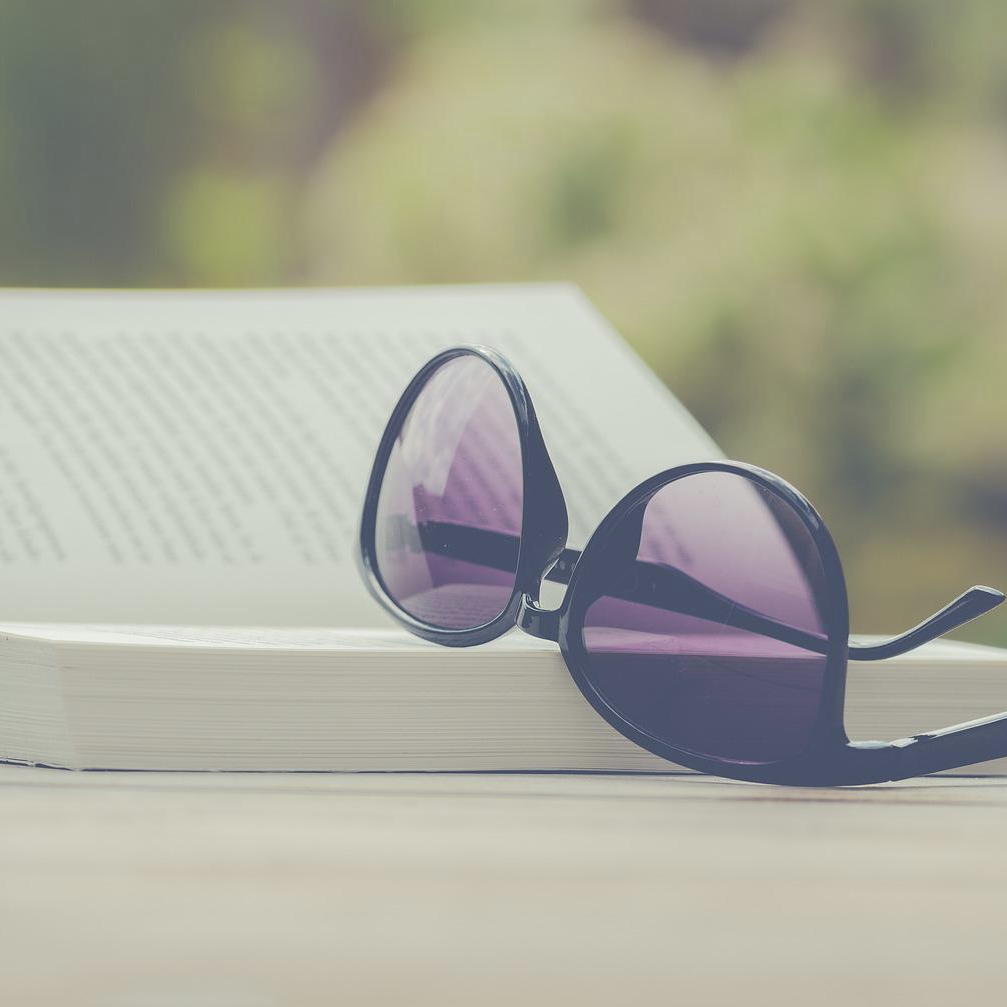 sunglasses resting on a book on a table