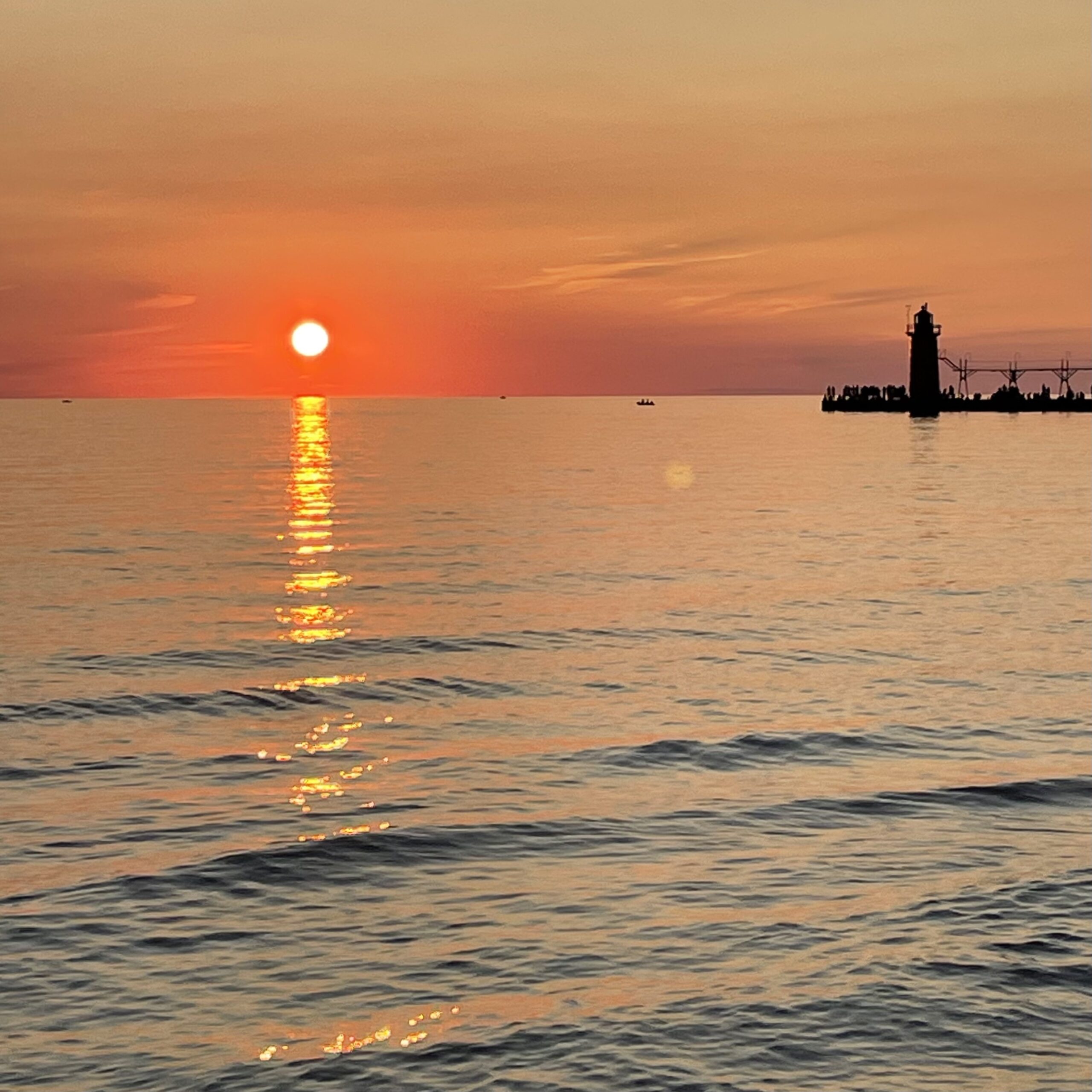 sunset over Lake Michigan lighthouse in silhouette