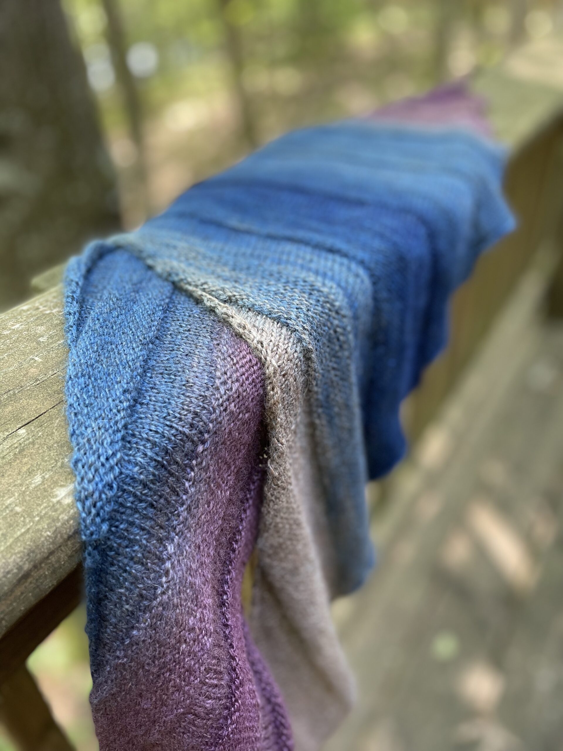 folded hand knit shawl shades of blue and purple close up